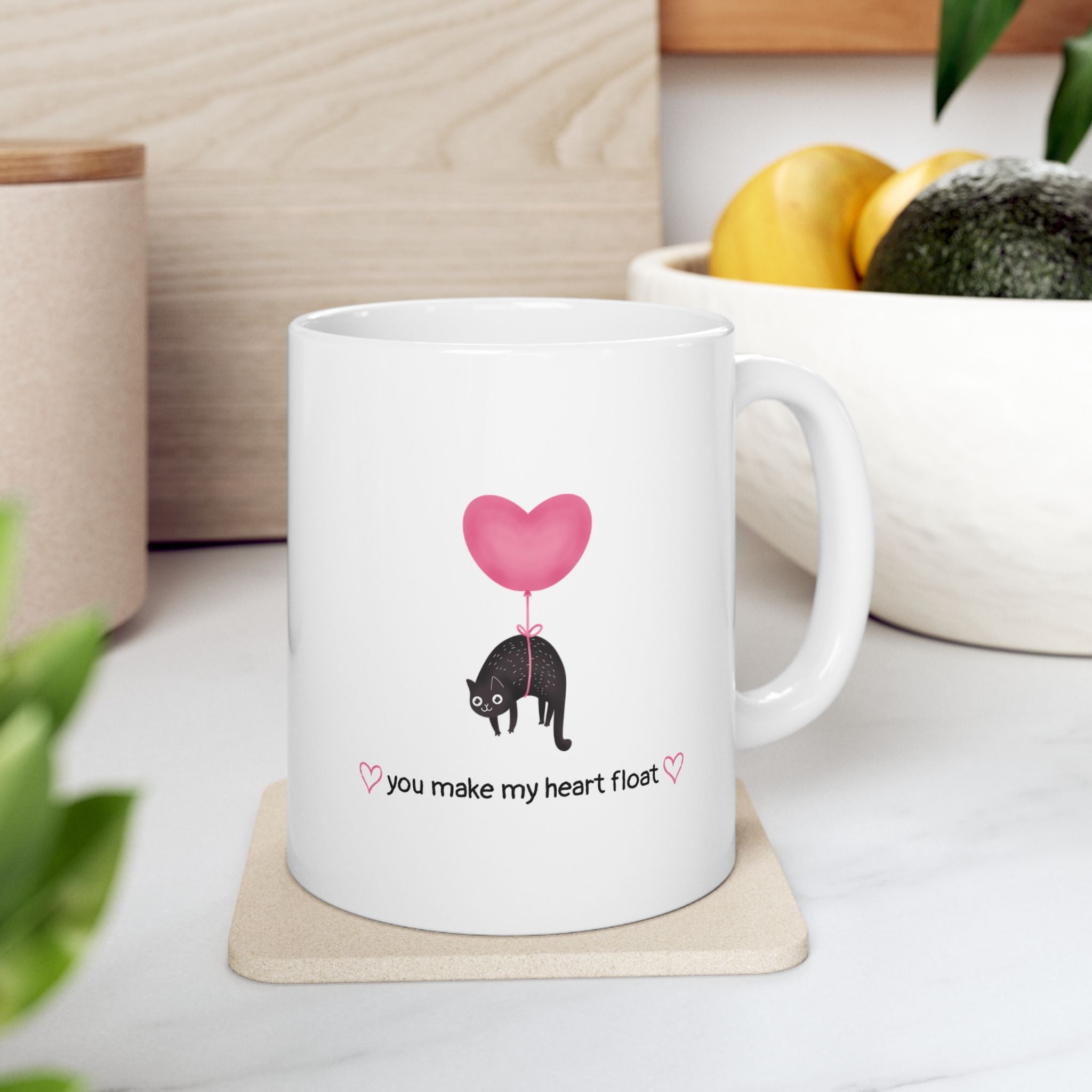 White mug on kitchen counter that says "you make my heart float"