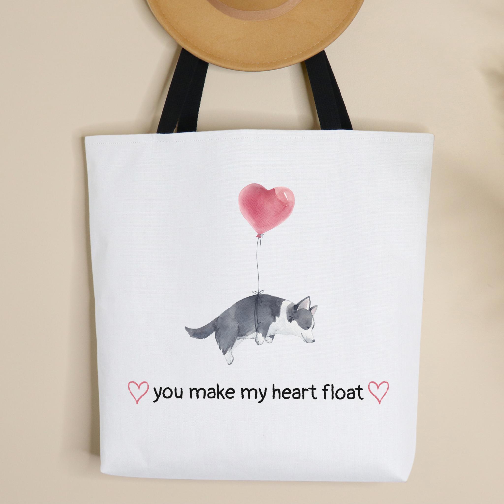 Tote bag with a dog and heart balloon design and text on a beige background